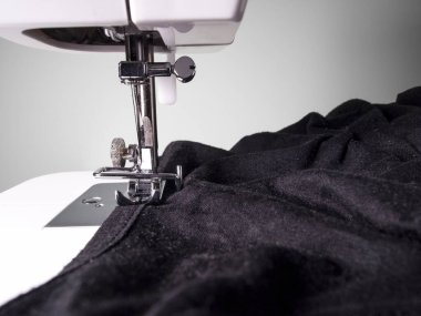 Beyaz arka planda siyah kumaşlı dikiş makinesi detayı. Anlaşıldı, siyah ve beyaz. Sanatsal kavram.