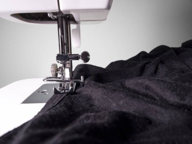 Beyaz arka planda siyah kumaşlı dikiş makinesi detayı. Anlaşıldı, siyah ve beyaz. Sanatsal kavram.