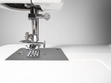 Beyaz duvar arka planında dikiş makinesi detayı var. Anlaşıldı, siyah ve beyaz. Sanatsal kavram.