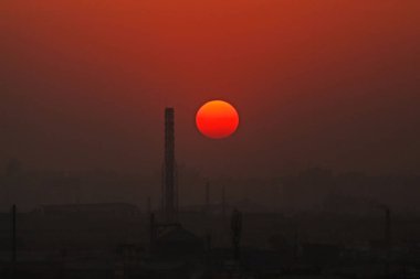Şehrin sanayi bölgesinde renkli dramatik günbatımı gökyüzü.