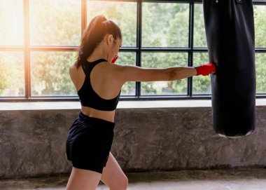 Kadın Muay Thai boksörü dövüşü. Spor giyim bölümünde formda genç bir bayan boksör..