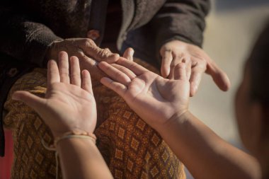 Büyükannesinin elini tutan genç bir kadın. İnsanlar, aile ve aşk kavramı..