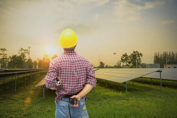 Mühendis kontrol ve bakım elektrik ekipmanları üzerinde çalışıyor; mühendis müfettişi güneş enerjisi santralinin elektrik sistemini inceliyor.
