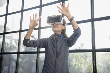 Güzel bir kadın VR sırasında havaya dokunuyor.