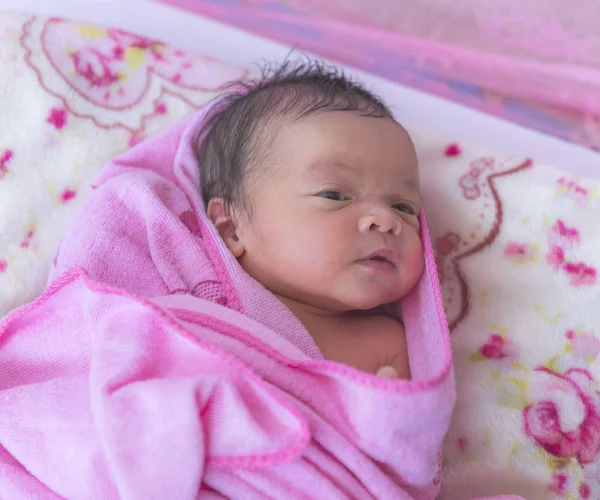 Newborn baby laying on the white blanket