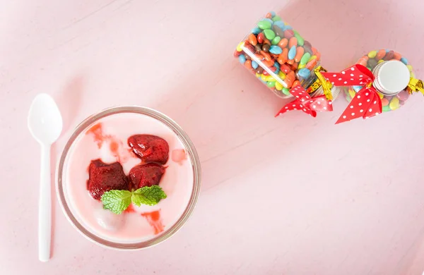 Iogurte de morango com morango em fundo rosa. palangreiro — Fotografia de Stock