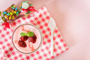 Çilekli yoğurt çilek üzerinde pembe bir arka plan ile. strawberr