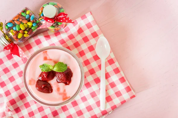 Çilekli yoğurt çilek üzerinde pembe bir arka plan ile. strawberr