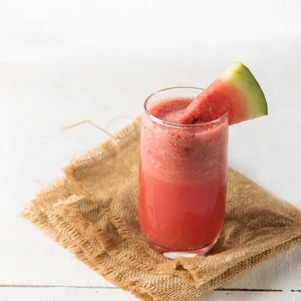 Jugo de sandía sobre fondo blanco de madera — Foto de Stock