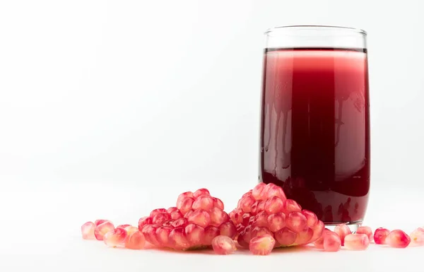 Glass of pomegranate juice with fruit isolated on white. — Stock Photo, Image