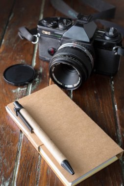 boş defter ile bir tükenmez kalem ve eski vintage fotoğraf makinesi
