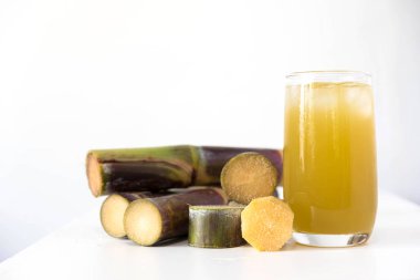 Taze şeker kamışı suyu cam masa beyaz arka plan üzerinde