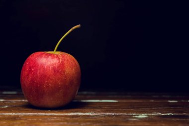 Kırmızı elma ahşap arka plan üzerinde yalnız tek