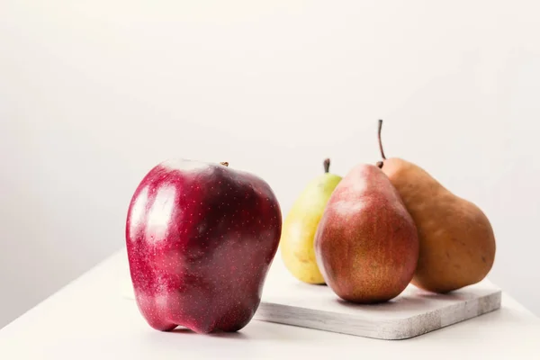 Pomme rouge simple et poire sur table blanche — Photo