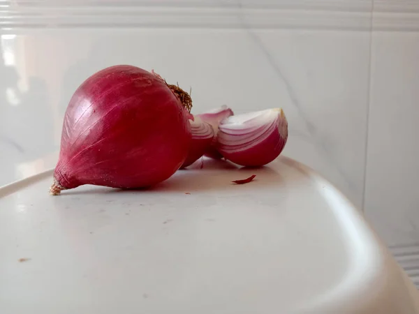 Bonita cebolla picante pelada y fresca de color rosa cortada en tres partes — Foto de Stock