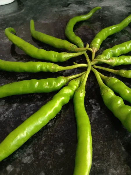 Fresh hot green chillies in decor in star shaped and dark backgr