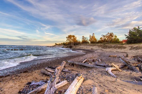 Scenic Autumn Lake Superior Beach Background. Driftwood beach on Lake Superior with the Whitefish Point Lighthouse. Whitefish Point is in the Upper Peninsula of Michigan on the shipwreck coast.