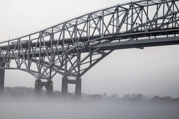 Urban Bridge In Fog Background. The International Blue Water Bridge in heavy fog. The Blue Water Bridges connect Port Huron, Michigan, USA and Sarnia, Ontario in Canada.