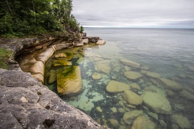 Deniz kıyısı uçurumlarda. Kristal suları Michigan'ın üst Yarımadası'nda Superior gölünün kıyısında kayalık uçurum.