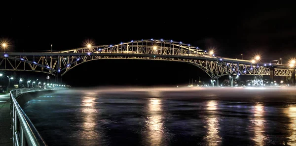 International Blue Water Bridge Crossing. The twin spans of the Blue Water Bridges between Port Huron, Michigan and Sarnia, Ontario with fog rolling in. This crossing is the second busiest border between the two countries.