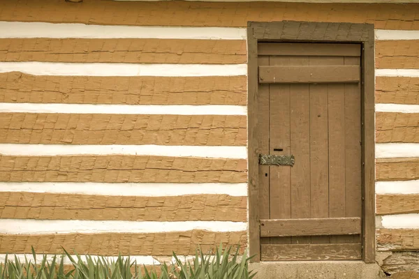 丸太小屋の外面および前部ドア コピースペースが付いている歴史丸太小屋の外壁そして閉鎖した正面玄関 — ストック写真