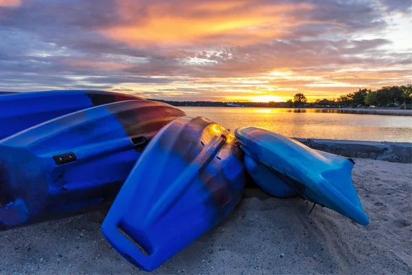 夏季皮艇日出 一排五颜六色的皮艇线岸边的沙滩 日出的颜色反映在平静的水域密歇根湖 横穿城市 密执安 — 图库照片