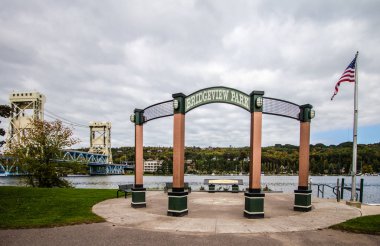 Houghton Michigan şehir merkezindeki Bridgeview Park 'ın arka planında tarihi Portage Lift Köprüsü var.