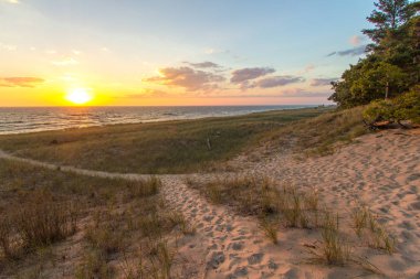 Summer Beach Sunset Manzarası. Muskegon, Michigan 'daki Hoffmaster Eyalet Parkı' nda gün batımı kumlu sahilde dolambaçlı bir yol..