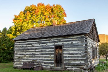 Tarihi Kütük Kulübesi. Öncü yerleşimcilerin kulübesi güz yapraklarıyla çevrili ve şimdi Michigan 'da tarihi bir bölge olarak korunuyor..