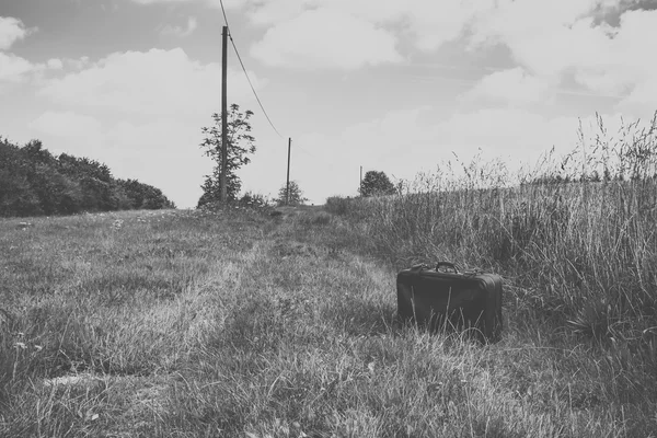 Suitcase on a dirt road — Stock fotografie