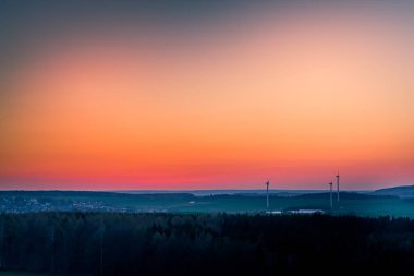 Turuncu günbatımında rüzgar türbinleri