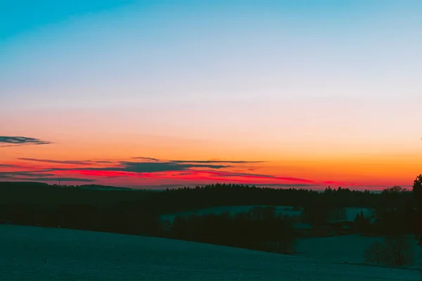 Pôr do sol idílico sobre um campo no inverno — Fotografia de Stock