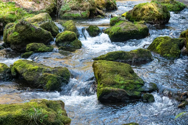 在自然环境和资源的概念中 水流湍急的河流或溪流 周围环绕着绿色苔藓岩 呈白色湍流 — 图库照片