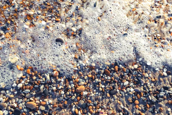 Pebble on the beach as background — Stock Photo, Image