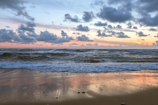 Színes sunset át a tengeren és a hullámok, mint háttér — Stock Fotó