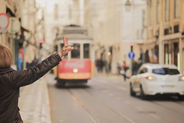 Un viajero llamando a uno de los viejos tranvías en el centro de Lisboa — Foto de Stock