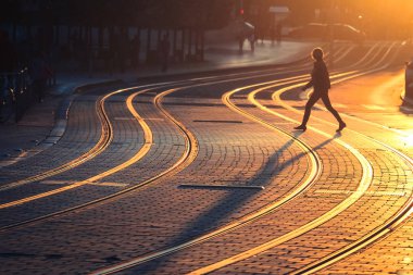 Gün batımı sırasında tramvay demiryolu üzerinde yürüyen bulanık kadın