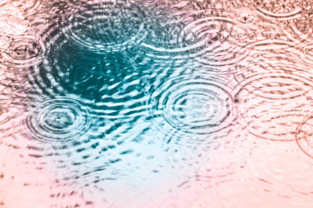 Blurred of water ripples and drops in turquoise and pink color 