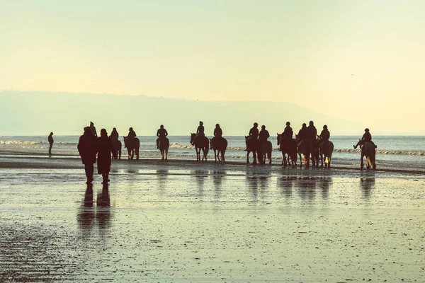 Silhouette de personnes à cheval sur la plage — Photo