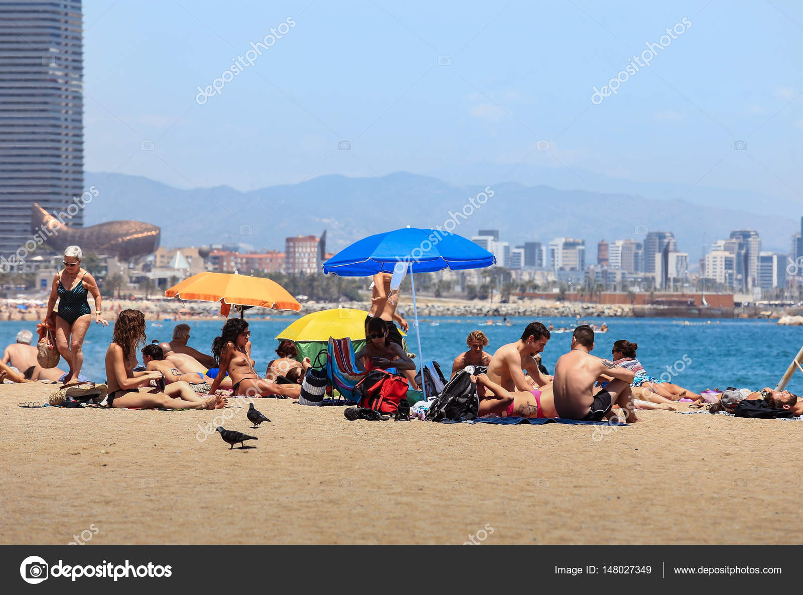 People Relaxing On The Beach In Barcelona Spain Stock