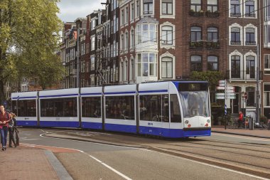 Amsterdam-Hollanda, 18 Nisan 2017: Amsterdam 'da modern tramvaylı sokak sahnesi, şehir merkezine girip çıkmanın en hızlı yollarından biridir.