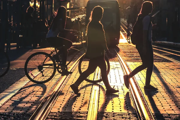 Bisiklet sürme ve sokakta günbatımı sırasında Bordeaux şehir yürüyüş insanlar