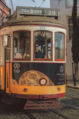 LISBON - PORTUGAL, 23 Aralık 2015: Lizbon, Portekiz şehir merkezinde eski bir geleneksel tramvay vagonu. Şehir, başkentin tarihi bölümünde geleneksel tramvayı hizmette tutuyordu.