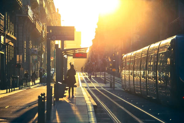 Bordeaux, Fransa - 1 Ekim 2017: şehir sokak sahne, tramvay ile Caddesi'ndeki Bordeaux, Fransa'da günbatımı sırasında yürüyüş insanlar üzerinde seçici odak