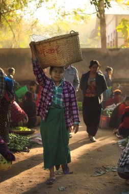 Bagan, Myanmar - Fabruary 3, 2017: Satıcı sepet Yong U Pazar sabah markette sun ray ile onun kafasına tarih seçici odak