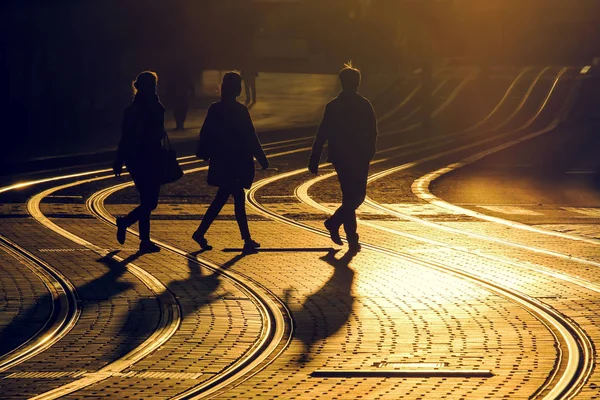 Street photography of friends take a walk on tram railway during the sunset in Bordeaux city, France.