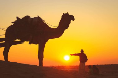 İnsanlar gün batımında Jaisalmer 'de Thar Çölü' nde günbatımının tadını çıkarırlar. Thar Çölü, Hindistan 'ın kuzeybatısında büyük bir kurak bölgedir..