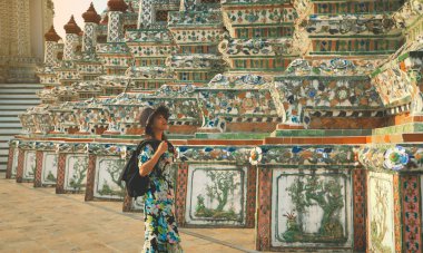 Wat Arun Ratchawararam 'da seyahat eden Asyalı genç kadın turist üzerinde duruluyor. Tayland, Bangkok' taki en ünlü turistlerden biridir..