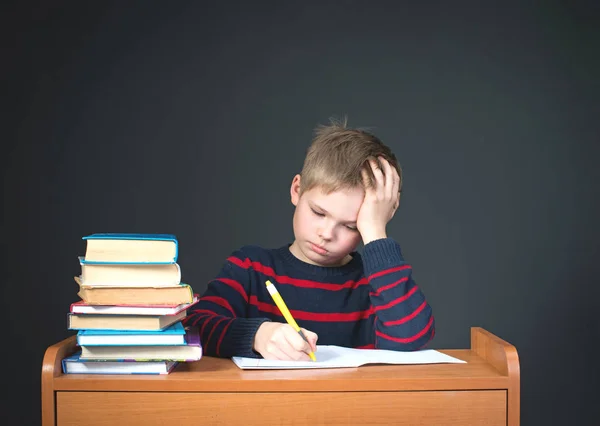 Infelice stanco ragazzino che fa i compiti. Studi scolastici noiosi. Concetto educativo . Foto Stock