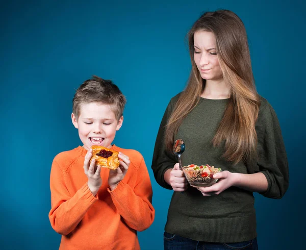 Hälsosam mat. Barn att välja mellan spannmål och bakverk. Kost. Bantning koncept. — Stockfoto